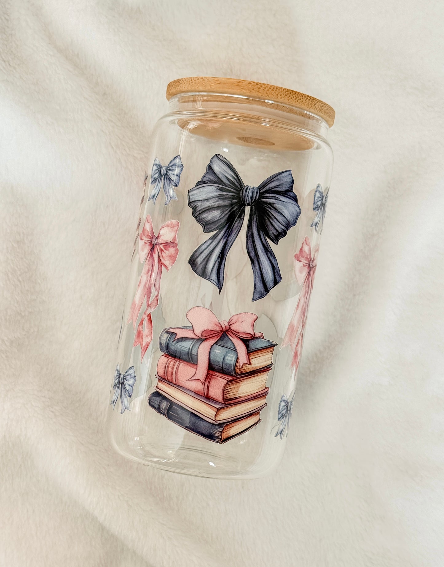 Glass jar with bamboo lid featuring illustrations of books and bows on a white background